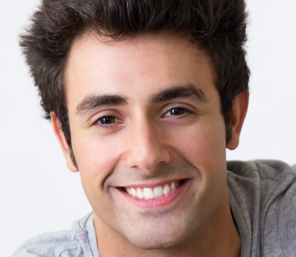 Young male with nice teeth sitting down and smiling