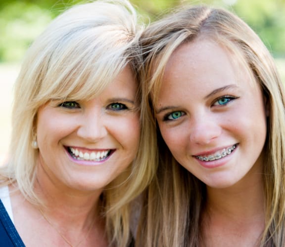 Mom holding her daughter with braces